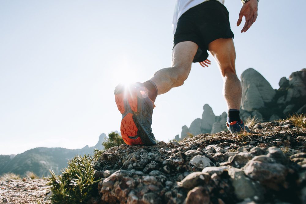 Gros plan sur des chaussures de trail sur un sentier rocheux